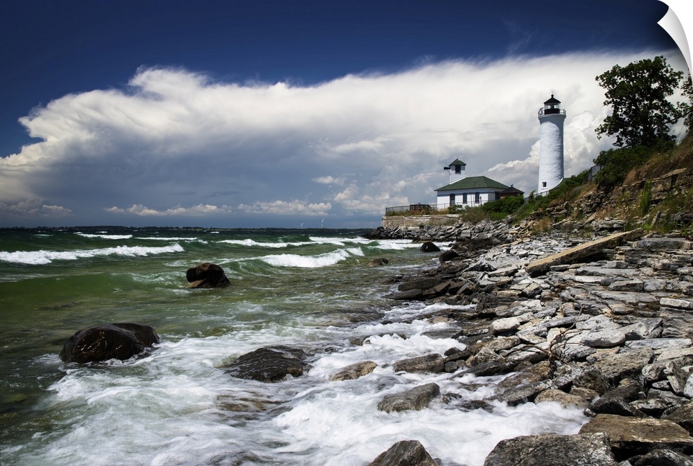 A storm moves over Tibbetts Point Lighthouse at Cape Vincent, New York, as waves crash into the banks of Lake Ontario. Thi...