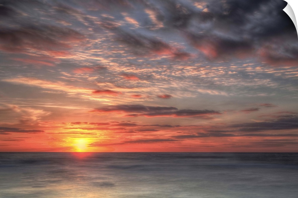 A coastal photograph of a seascape at sunrise.