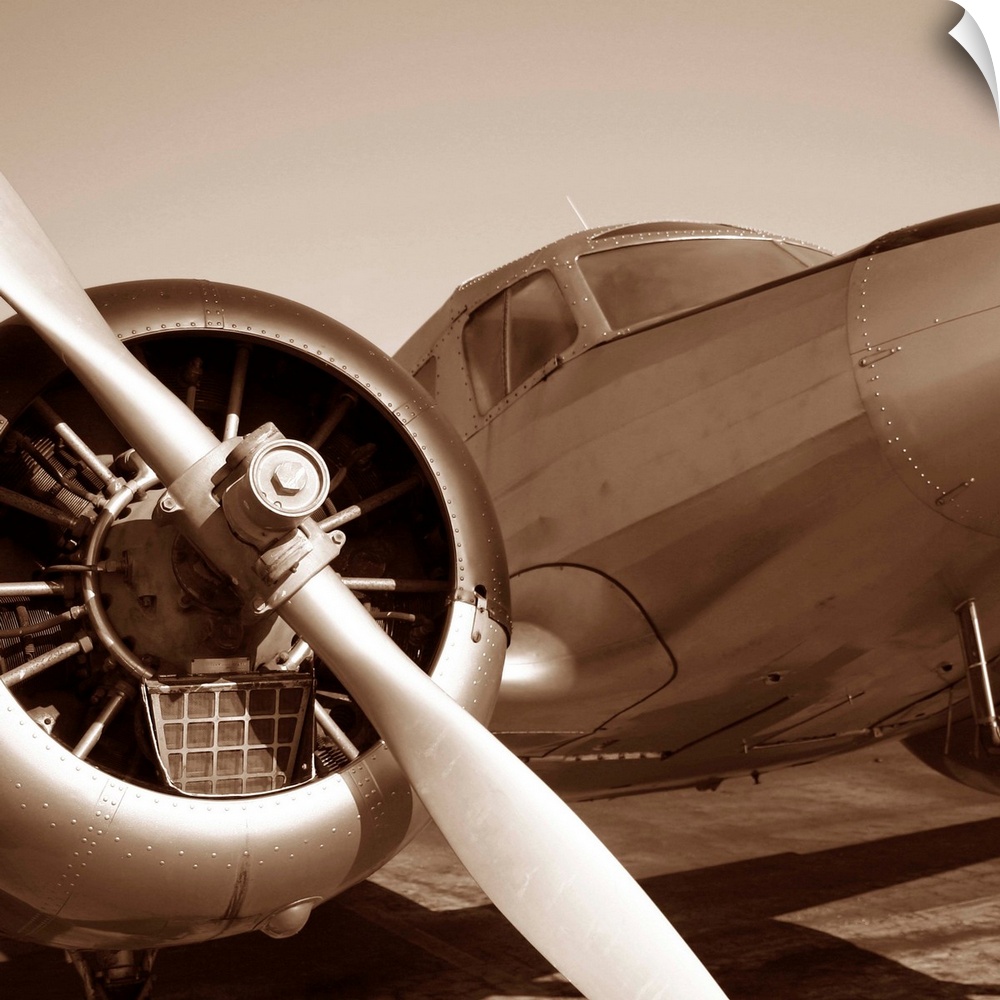 Square photograph of a plane from the view of the wing in a sepia tone.