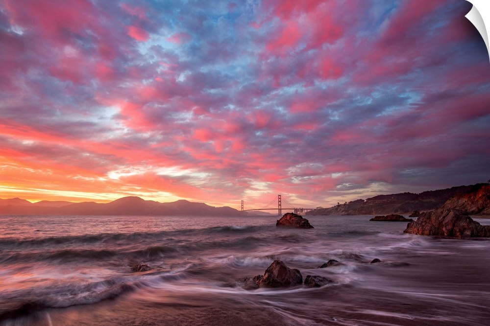 Photograph of the San Franciso bay at sunrise with pink and blue clouds overhead.
