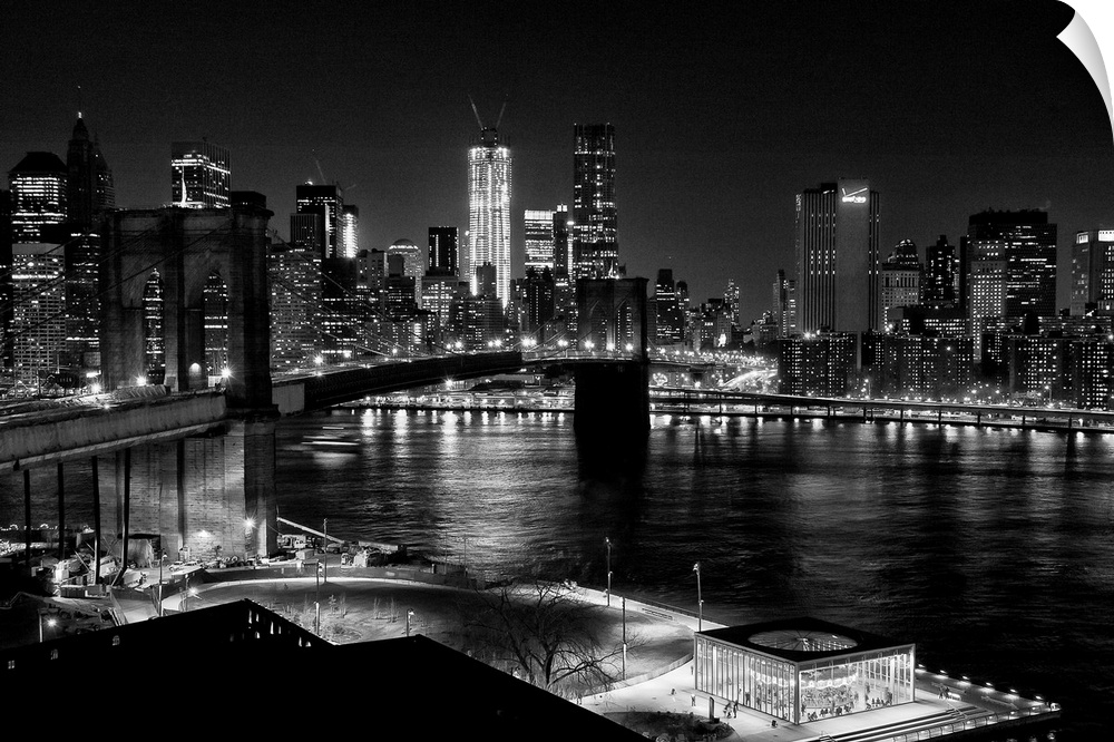 Black and white photograph of a city skyline at night. With abridge spanning over bay.