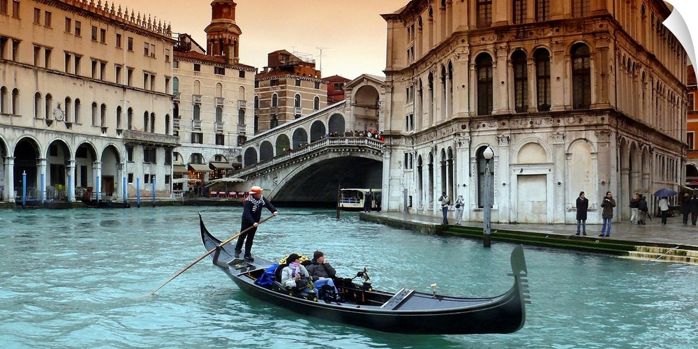 Panoramic image of a couple riding in a gondola in the canals of Venice, Italy.