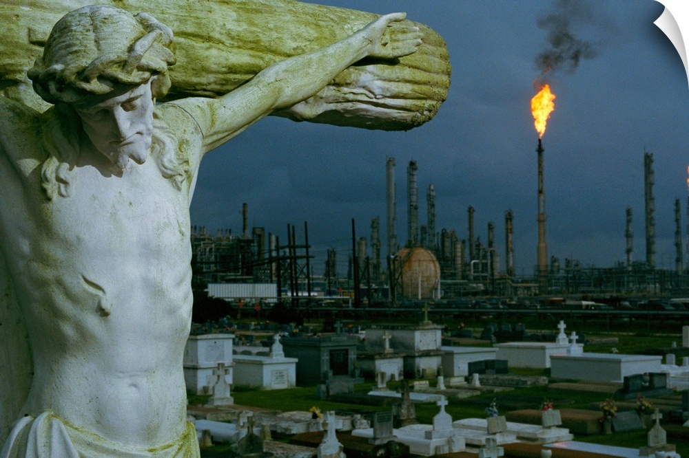 A crucifixion statue in Holy Rosary Cemetery overlooks petrochemical plants mas sed upriver from New Orleans to Baton Roug...