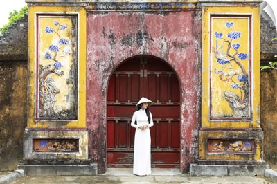 A Vietnamese Girl Stands In Front Of Historical Gate In Hue Imperial Citadel, Vietnam