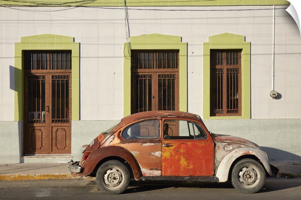 A vintage Volkswagen Beetle in front of a house in Merida, Yucatan, Mexico.