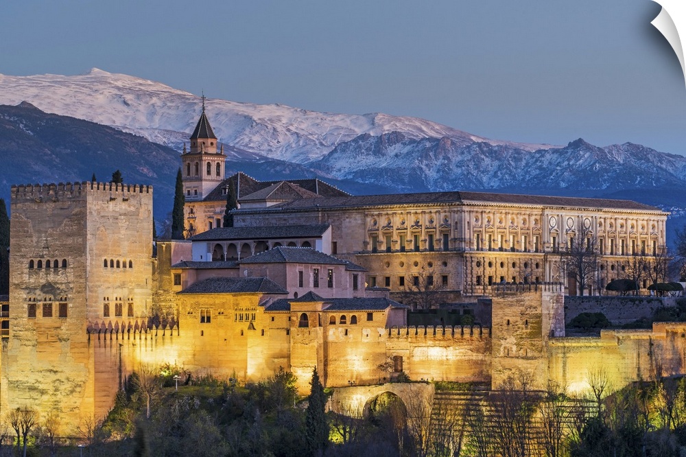 View at dusk of Alhambra palace with the snowy Sierra Nevada in the background, Granada, Andalusia, Spain.
