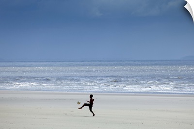 Brazil, Maranhao, Sao Luis, Sao Marcos beach, boy playing football on the beach