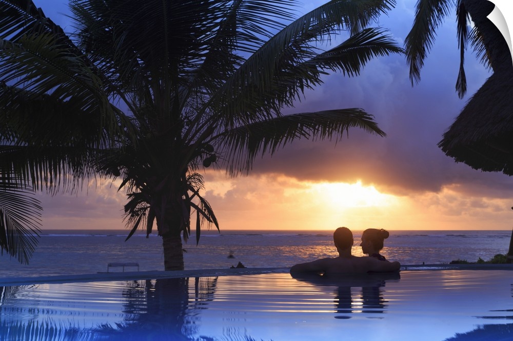 Tanzania. Zanzibar, Kigomani, Couple relaxing inside infinity pool overlooking the beach at luxurious resort (MR)