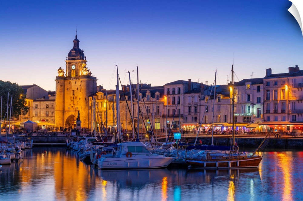 France, Poitou Charentes, La Rochelle, Old Harbour, Porte de La Grosse Horloge at dusk.