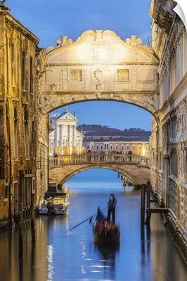 Italy, Veneto, Venice. Bridge of sighs illuminated at dusk with gondolas