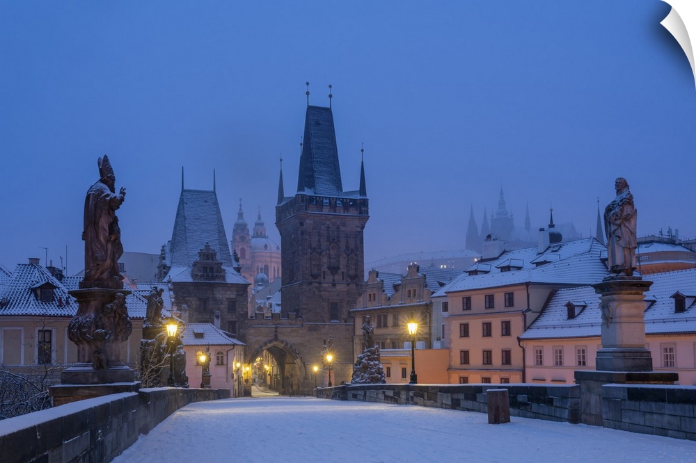 Mala Strana Bridge Tower at snow-covered Charles Bridge at twilight in winter, Prague, Bohemia, Czech Republic. Prague, Ce...