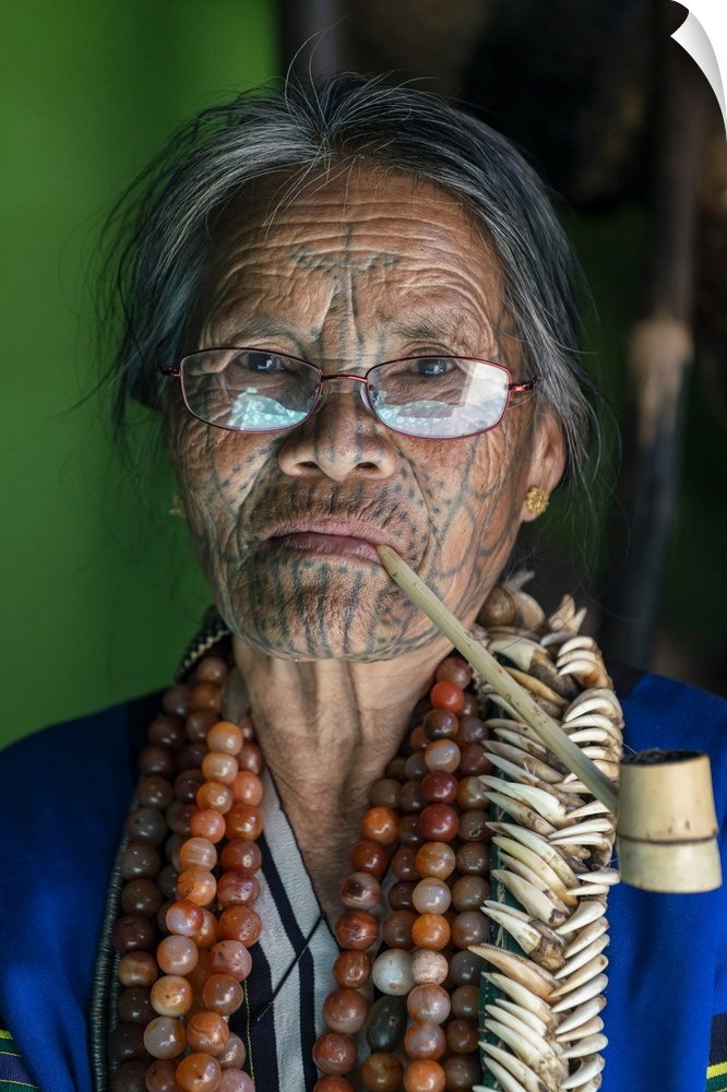 Close-up portrait of old lady with glasses and traditional facial tattoo smoking a pipe, Mindat, Mindat Township, Mindat D...