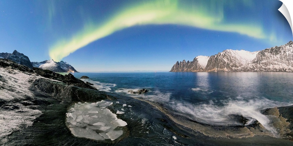Panorama of frozen sea and rocky peaks illuminated by the Northern Lights Tungeneset Senja Tromso Norway Europe