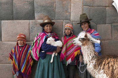 Peru, Cusco, Quechua people standing in front of an Inca wall