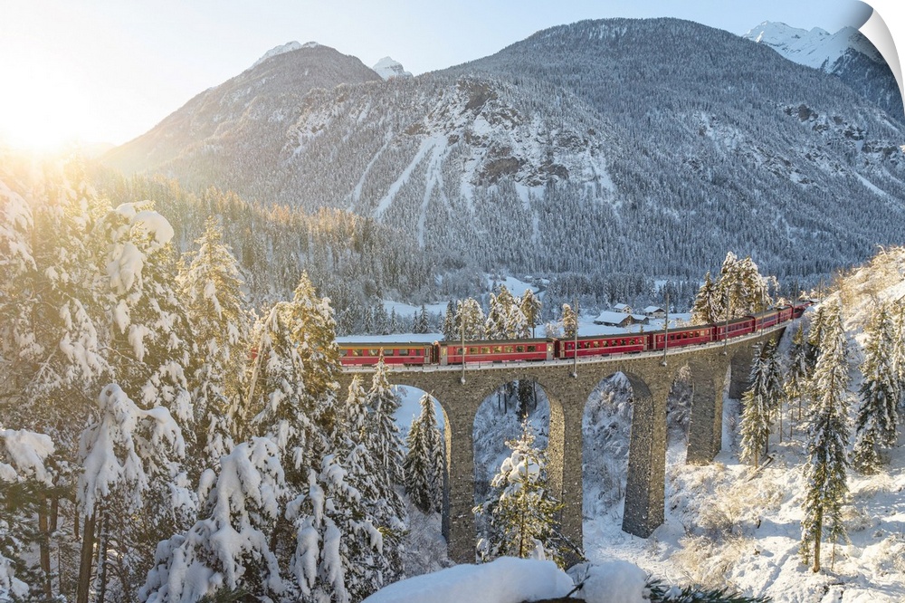 Red train traveling in the winter snowy landscape from Filisur to Tiefencastel railway station, aerial view, Graubunden, S...