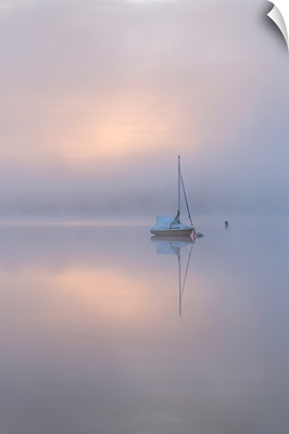 Sailing boat at dawn on Wimbleball Lake, Exmoor National Park, Somerset, England.