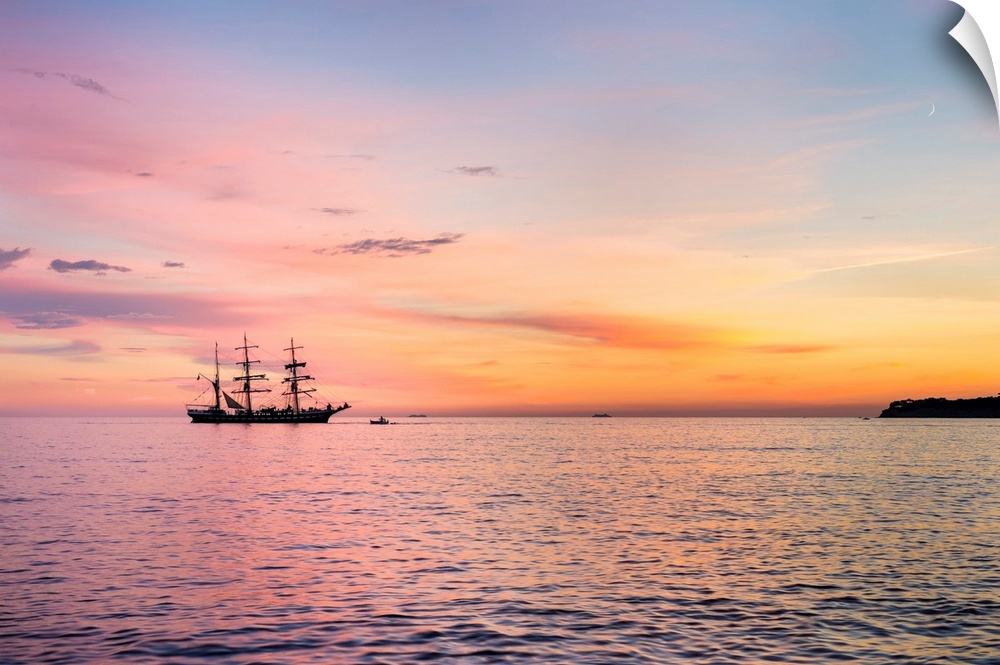 Silhouette of sailing ship at sunset off the coast of Cassis, Bouches-du-Rhone, Provence-Alpes-Cote d'Azur, France.