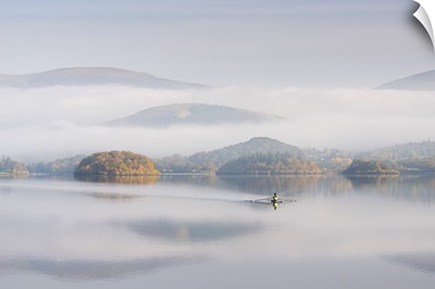 Single sculler rowing across a misty Derwent Water, Lake District, Cumbria, England.