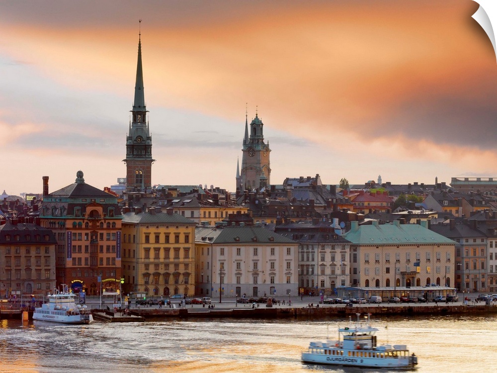 Sweden, Stockholm, Riddarfjarden, Gamla Stan; passenger ferries in bay at dusk.