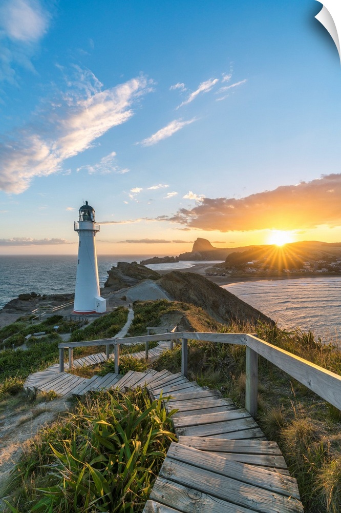 The sun is setting down behind Castle Rock and Castlepoint lighthouse. Castlepoint, Wairarapa region, North Island, New Ze...