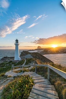 The Sun Is Setting Down Behind Castle Rock And Castlepoint Lighthouse, New Zealand