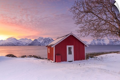 Traditional Norwegian house during a sunset on the fjord.