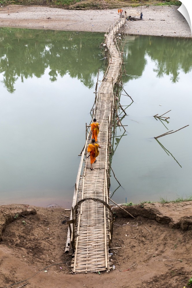 Two buddhist monks walk across bamboo bridge, Luang Prabang, Louangphabang Province, Laos