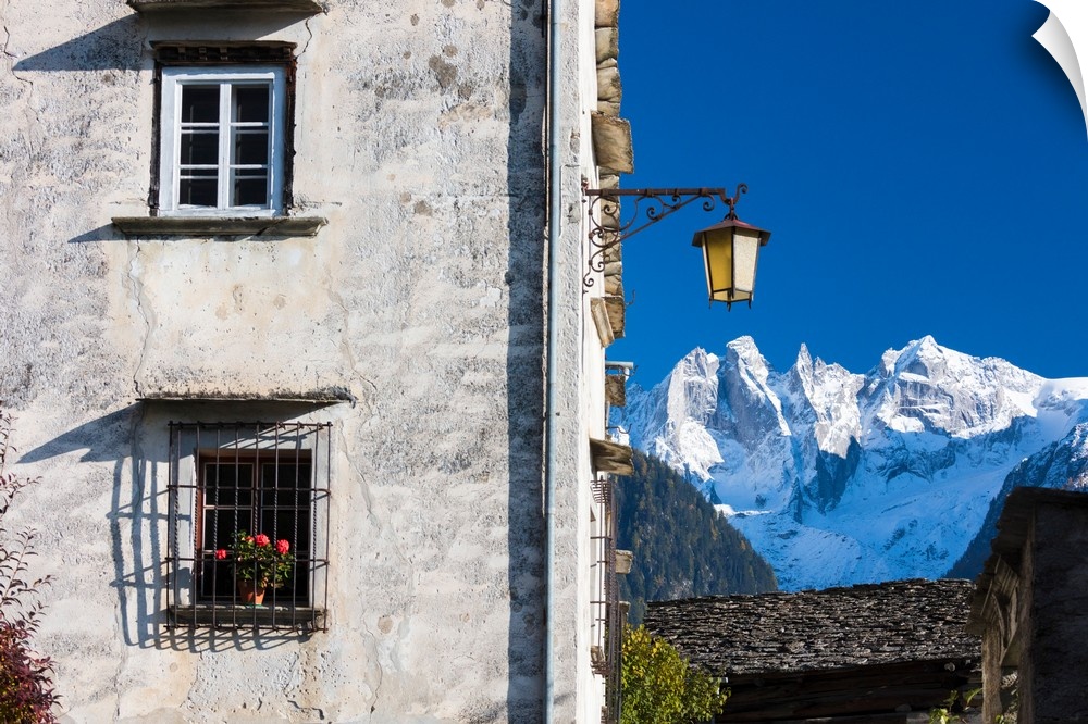 Typical alpine house and street lantern frame the snowy peaks Soglio Bregaglia Valley canton of Graubunden Switzerland Europe