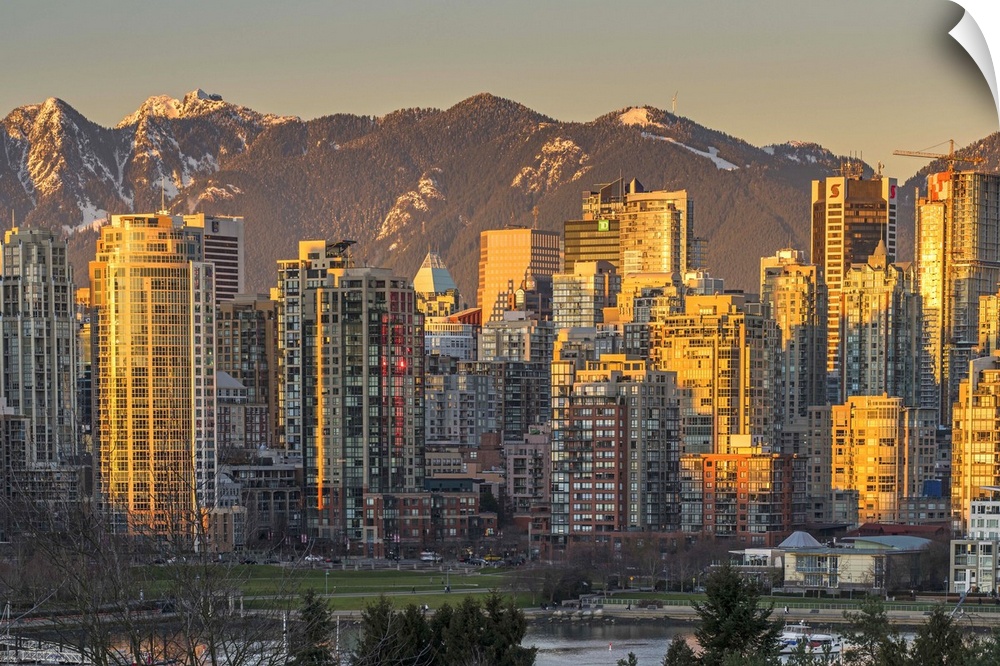 Downtown skyline with snowy mountains behind at sunset, Vancouver, British Columbia, Canada.