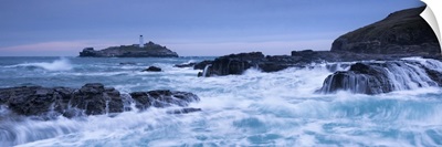Waves crash around the rocks near Godrevy Lighthouse, Cornwall, England