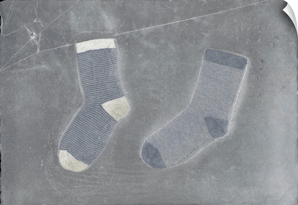 Two striped children's socks suspended in handmade paper.