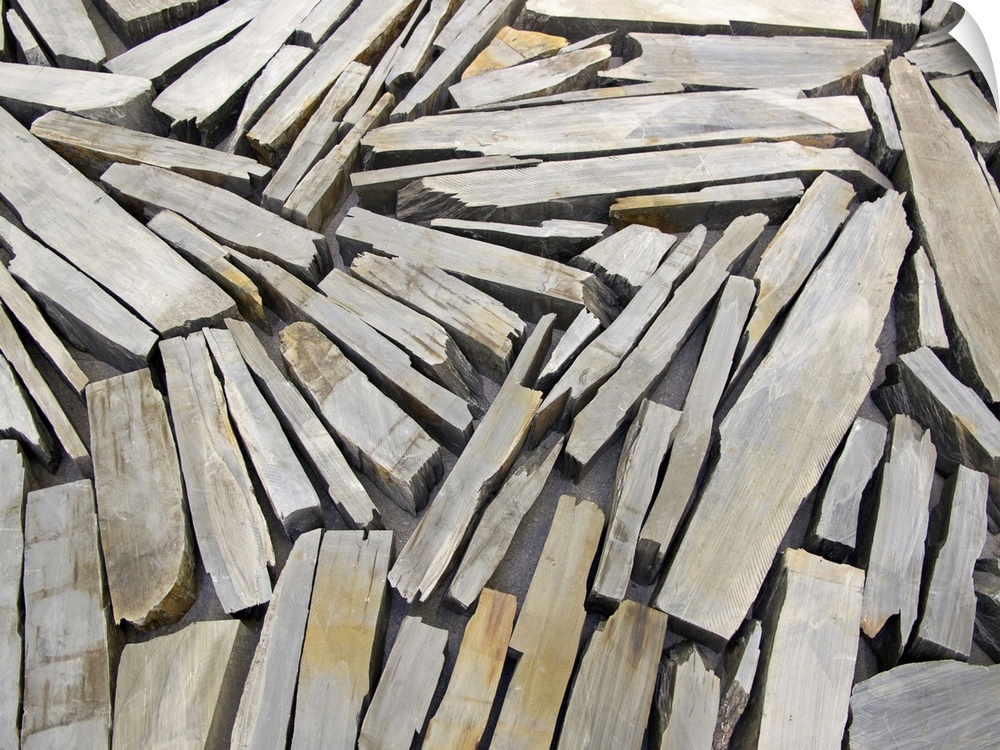 Photograph of wood pieces varying in length and width, and oriented in all directions, arranged in a collage-like manner.