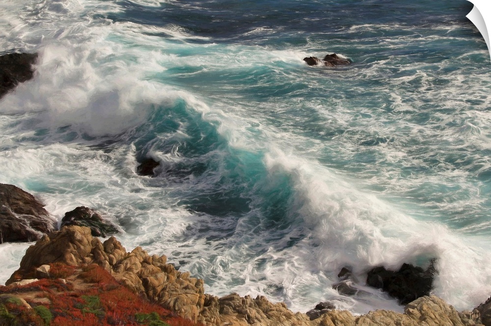 Gorgeous teals and blues are set in motion by a crashing wave in Big Sur, contrasting with the reds and browns of the rock...