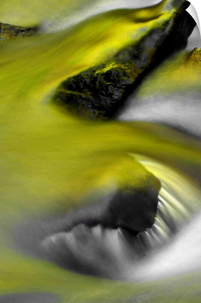 This picture was taken closely of rushing water over moss covered rocks.