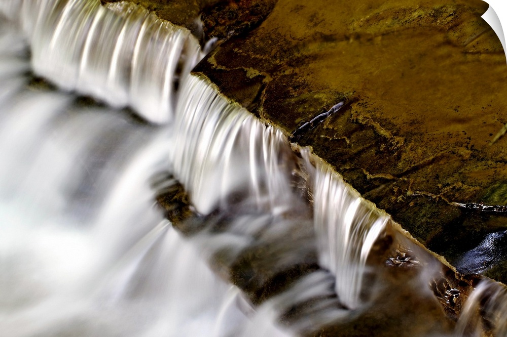 Large photo print of water rushing downward off of rock formations.