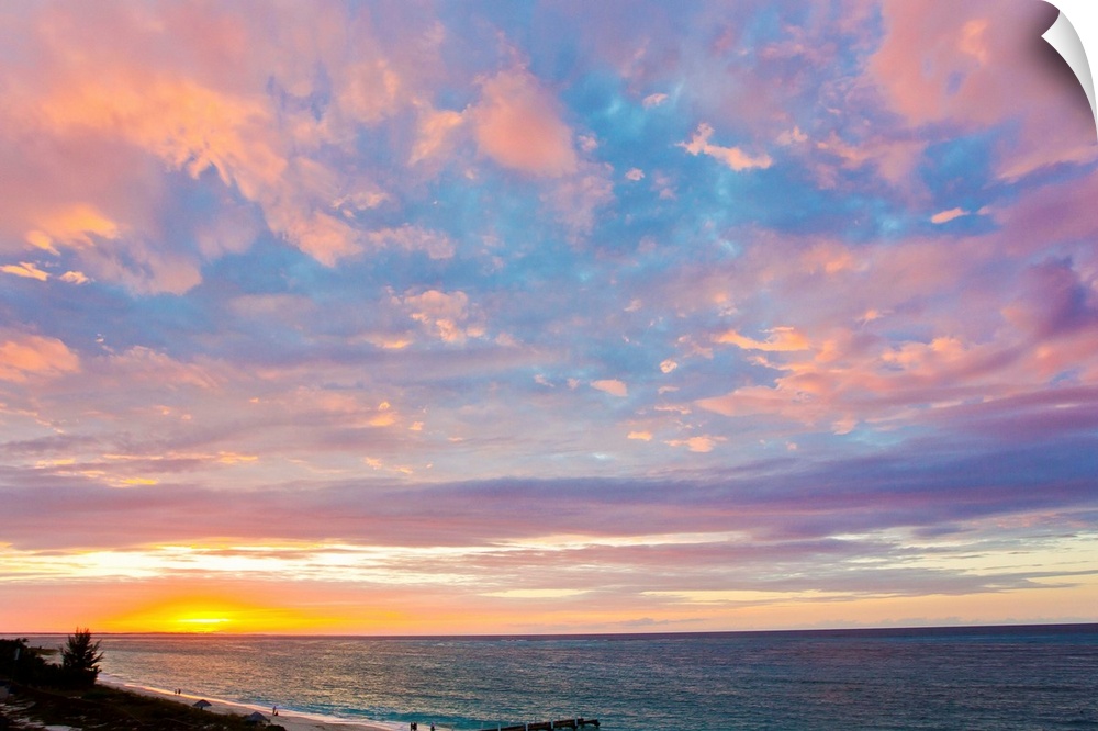 A beautiful delicate pink and purple sky at sunset over Grace Bay, and the shore.