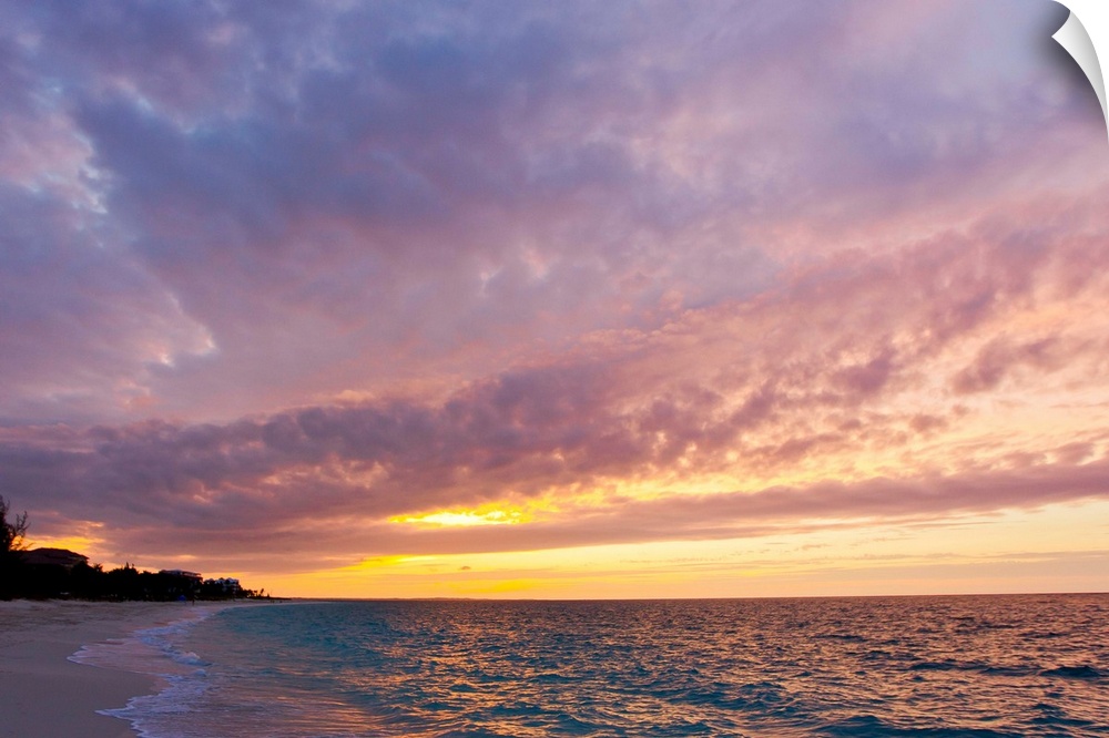 A purple and pink sky at sunset over Grace Bay and the beach.