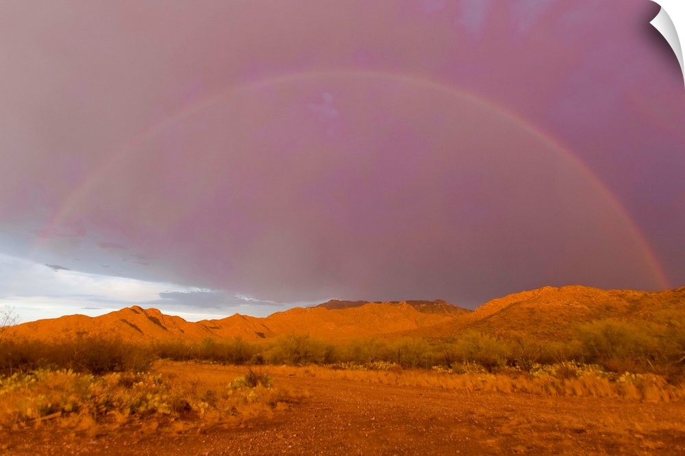 Rainbow and purple sky on the backside of thunderstorm in a desert.