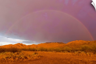 Rainbow and purple sky on the backside of thunderstorm in a desert