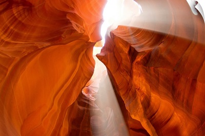 Sunlight streams through cracks in a slot canyon