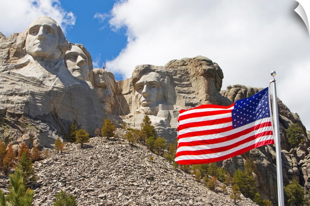 The United States flag proudly flying in front of Mount Rushmore.