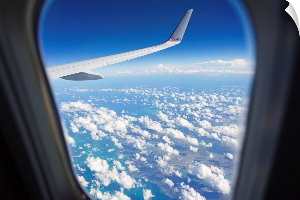 View through a passenger airplane window flying over the Caribbean.