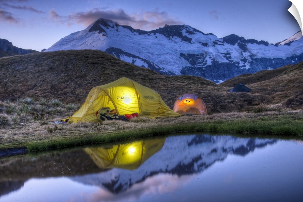 Campers read in tents lit by flashlight, Cascade Saddle, Mount Aspiring National Park, New Zealand