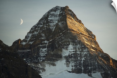 Crescent moon and summit of Mount Assiniboine, British Columbia, Canada
