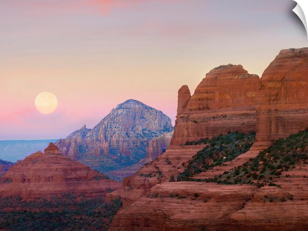 Large, horizontal photograph of the moon setting in the early morning sky, over the large rock formations near Shelby Hill...