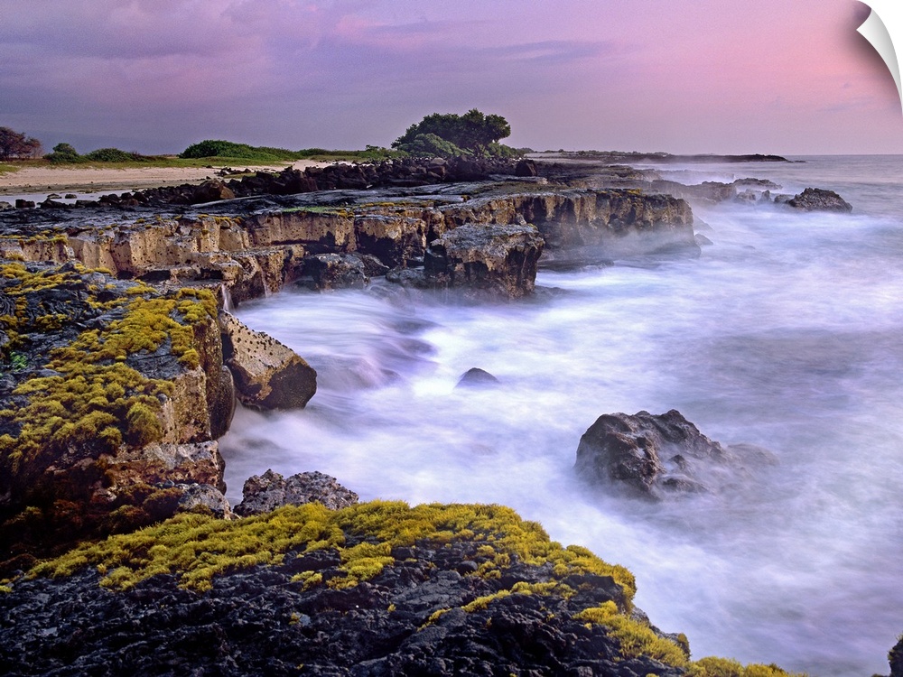 Photograph of rocky cliff line that drops into the ocean under a cloudy sky.