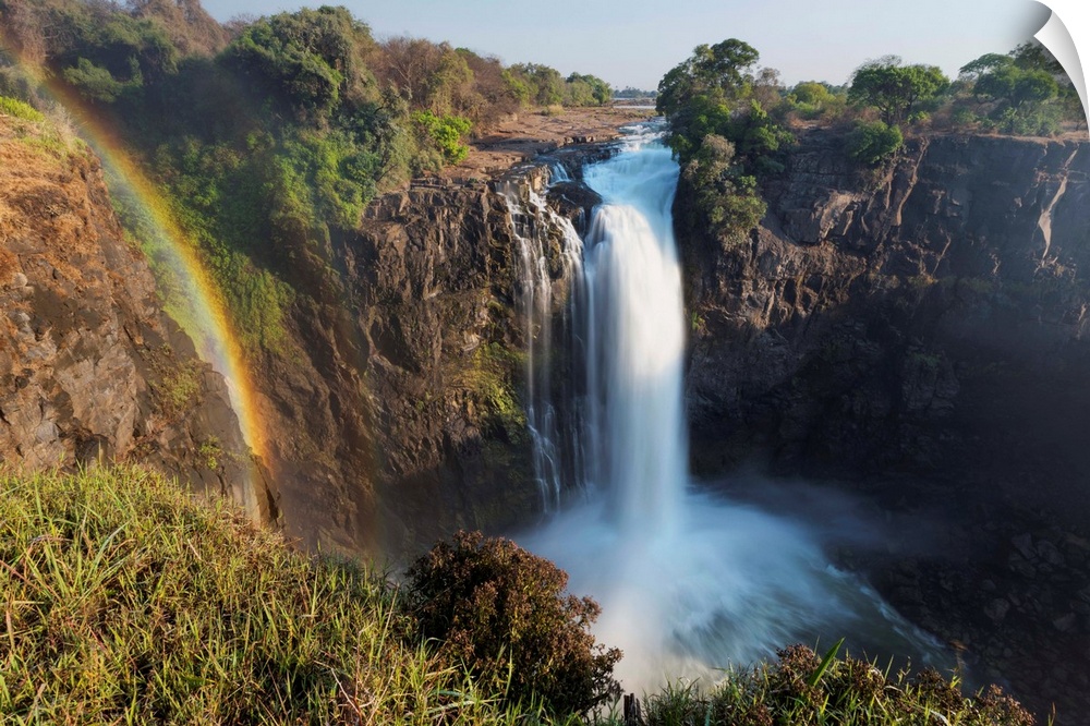 Rainbow formed in mist from waterfall, Victoria Falls, Zimbabwe.