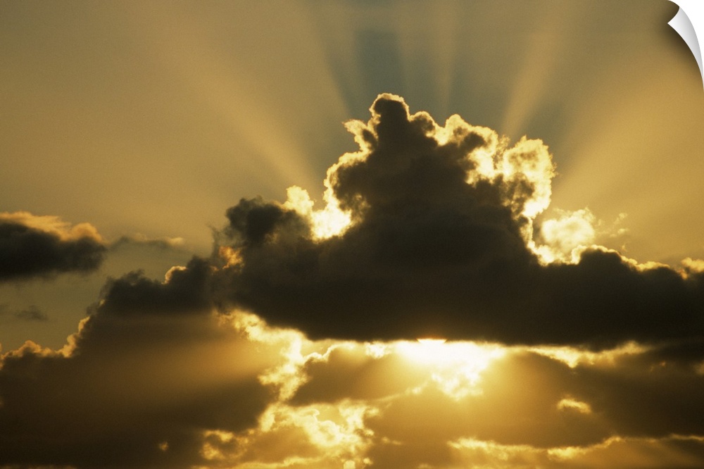 SUN RAYS BEAM FROM BEHIND CUMULUS CLOUDS,