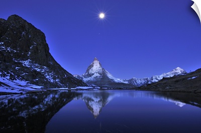 The Matterhorn reflected in the Riffelsee Lake under a full moon, Switzerland