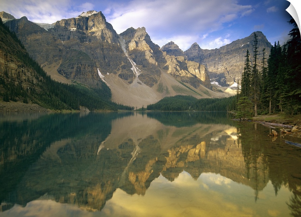 The towering mountains perfectly mirrored in a still glacial lake in the Canadian Rockies, creating a serene wilderness sc...